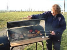 Smoky Jo tensing to smoked peppers, chickens and trout on a barrel smoker